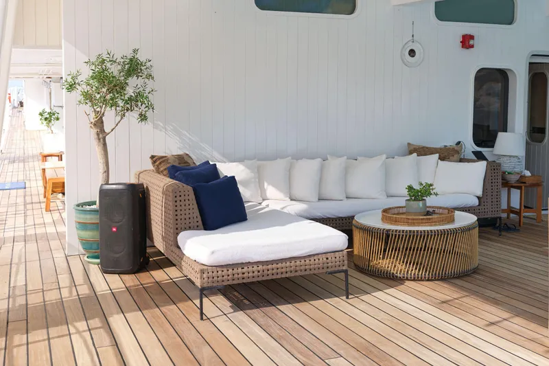 Hayama Yacht Photos Pics Luxurious yacht deck with wicker furniture, white cushions, and potted plants, Custom Hakodate Shipyard 1988.