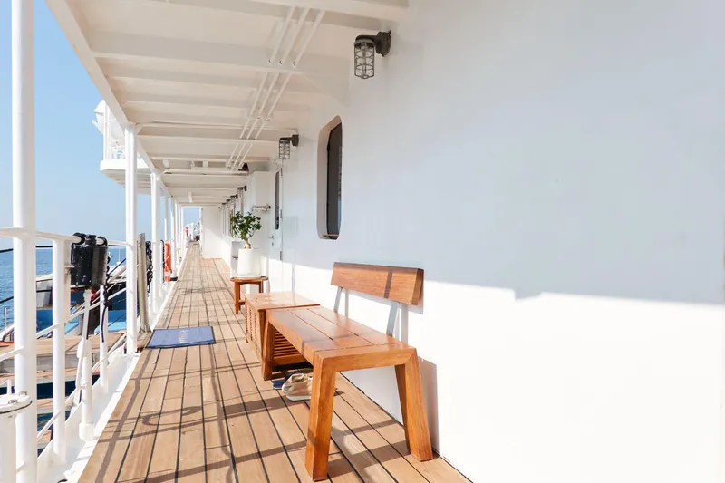 Hayama Yacht Photos Pics Wooden deck with bench on 1988 Custom Hakodate Shipyard vessel, featuring white walls and ocean view.