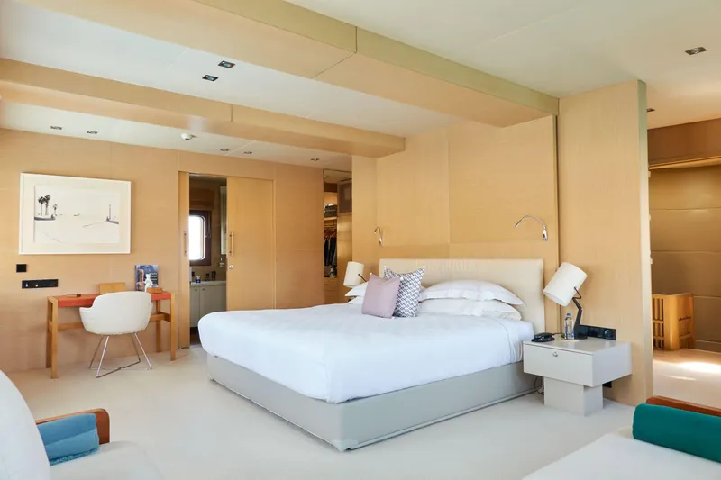 Hayama Yacht Photos Pics Luxurious yacht bedroom with modern decor, featuring a comfortable bed and elegant furnishings.