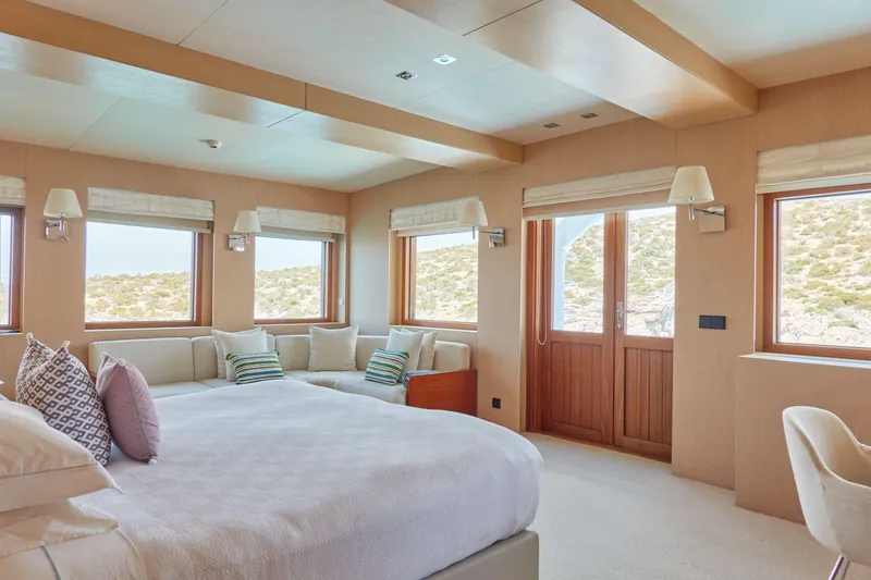 Hayama Yacht Photos Pics Luxurious ship cabin with large bed, windows, and cozy seating area, built by Hakodate Shipyard in 1988.