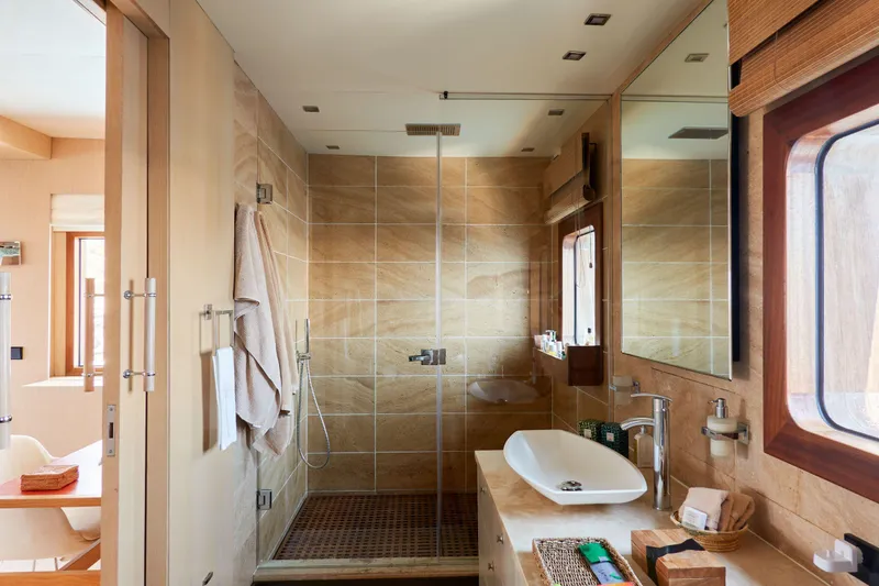 Hayama Yacht Photos Pics Luxurious bathroom with modern shower, vessel sink, and wooden accents on a 1988 Hakodate Shipyard custom model.