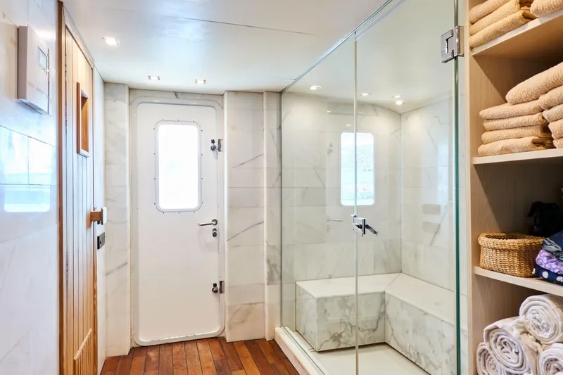 Hayama Yacht Photos Pics Luxurious ship bathroom with glass shower, wooden floor, and towel storage, Custom Hakodate Shipyard 1988.
