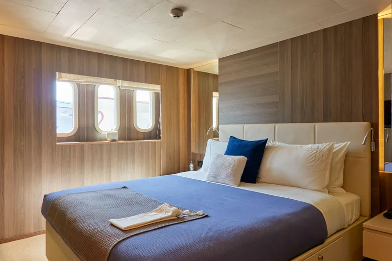 Hayama Yacht Photos Pics Luxurious ship cabin with a comfortable bed, wooden paneling, and porthole windows, Hakodate Shipyard 1988.