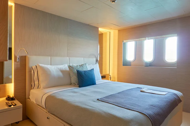 Hayama Yacht Photos Pics Luxurious ship cabin with cozy bed, modern decor, and porthole windows, built by Hakodate Shipyard.