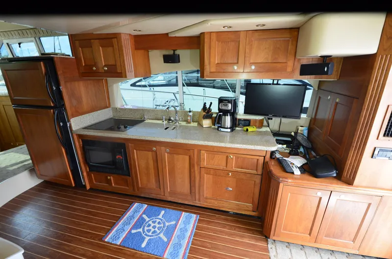 Tenacious Yacht Photos Pics 2003 Cruisers Yachts 5000 Sedan Sport kitchen with wooden cabinets and modern appliances.