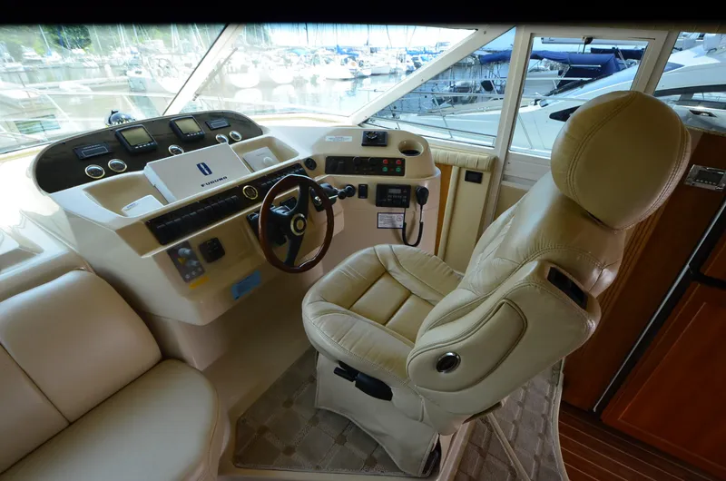 Tenacious Yacht Photos Pics 2003 Cruisers Yachts 5000 Sedan Sport helm with leather captain's chair and control panel.