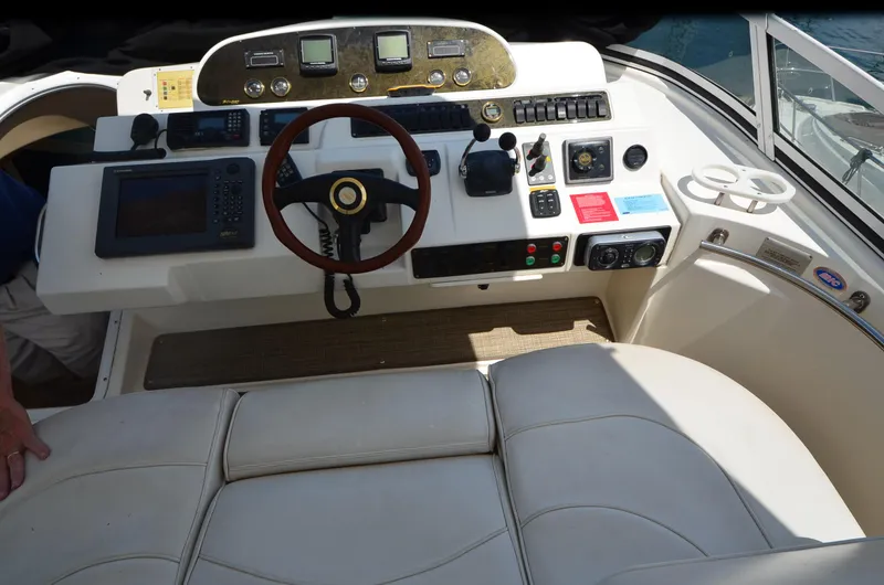 Tenacious Yacht Photos Pics 2003 Cruisers Yachts 5000 Sedan Sport helm with steering wheel and navigation controls.