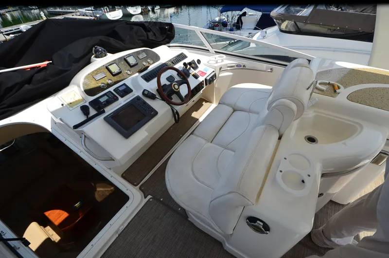 Tenacious Yacht Photos Pics 2003 Cruisers Yachts 5000 Sedan Sport helm with leather seating and navigation controls.