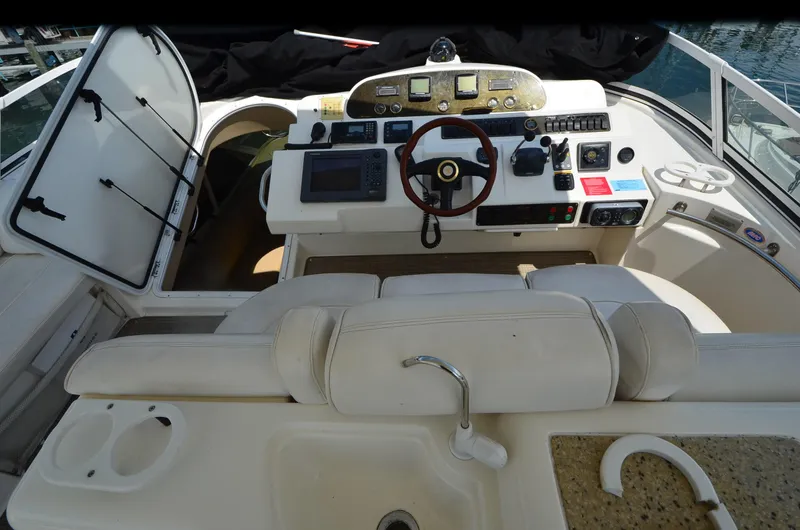 Tenacious Yacht Photos Pics 2003 Cruisers Yachts 5000 Sedan Sport helm with steering wheel and navigation controls.