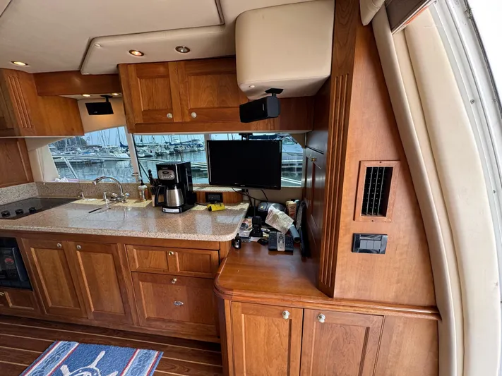 Tenacious Yacht Photos Pics Luxurious 2003 Cruisers Yachts 5000 Sedan Sport interior with wooden cabinetry and modern amenities.