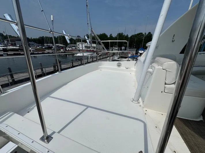 Tenacious Yacht Photos Pics 2003 Cruisers Yachts 5000 Sedan Sport deck, docked at marina under clear sky.