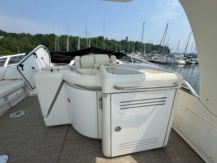 Tenacious Yacht Photos Pics 2003 Cruisers Yachts 5000 Sedan Sport deck with seating, docked at marina.