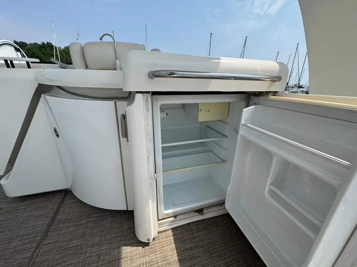Tenacious Yacht Photos Pics Open fridge on 2003 Cruisers Yachts 5000 Sedan Sport, showcasing interior storage space.