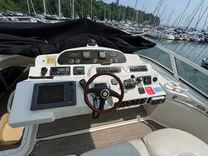 Tenacious Yacht Photos Pics Helm of 2003 Cruisers Yachts 5000 Sedan Sport with navigation equipment and steering wheel.
