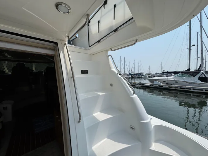 Tenacious Yacht Photos Pics 2003 Cruisers Yachts 5000 Sedan Sport, staircase view, docked at marina with boats.