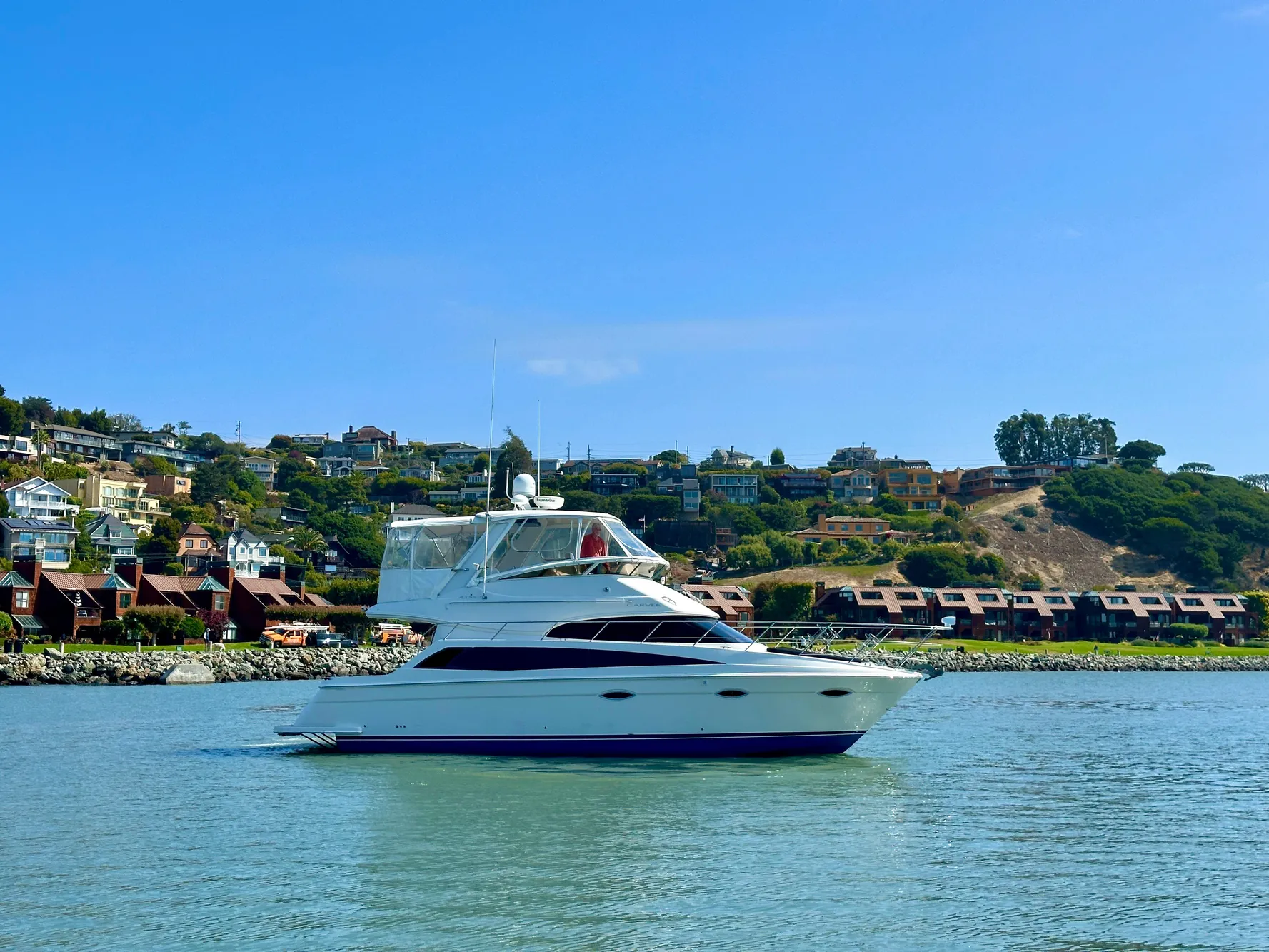 2008 Carver 43 Super Sport yacht on calm water with scenic hillside background.