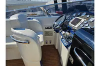 Luxury boat cockpit with white leather seats, modern steering, and control panel, Performance 1107, 2010.