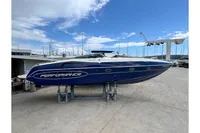 Blue 2010 Performance 1107 speedboat on dry dock, marina background, clear sky.