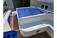 Luxurious 2010 Performance 1107 yacht deck with blue sunbed and white seating.