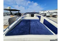 2010 Performance 1107 boat with blue seating, docked under a clear sky.