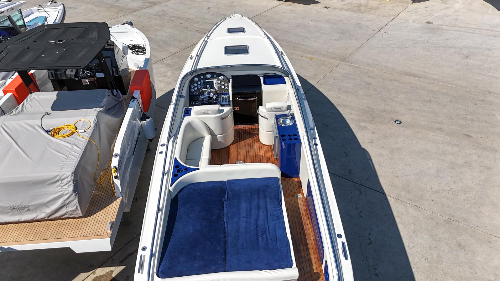 Performance 1107 boat, 2010 model, with blue seating and wooden deck, docked at marina.