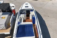 Performance 1107 boat, 2010 model, with blue seating and wooden deck, docked at marina.