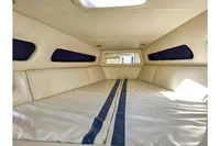 Interior cabin of 2010 Performance 1107 boat with beige upholstery and blue accents.