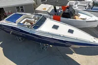 A 2010 Performance 1107 speedboat with a sleek blue and white design, docked outdoors.
