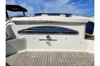 2010 Performance 1107 boat stern with chrome details and wooden deck under blue sky.