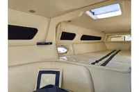 Luxurious interior of a 2010 Performance 1107 boat, featuring beige upholstery and sleek design.