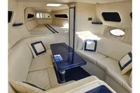 Luxurious interior of a 2010 Performance 1107 yacht with beige seating and blue accents.
