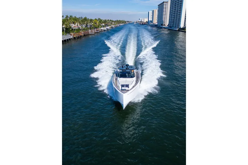  Yacht Photos Pics 2019 Pardo Yachts cruising through a scenic waterway with cityscape and palm trees.