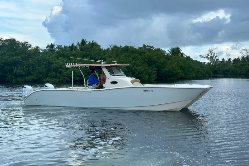  Yacht Photos Pics A 2009 Mamba 350 boat cruising on a calm river near lush greenery.
