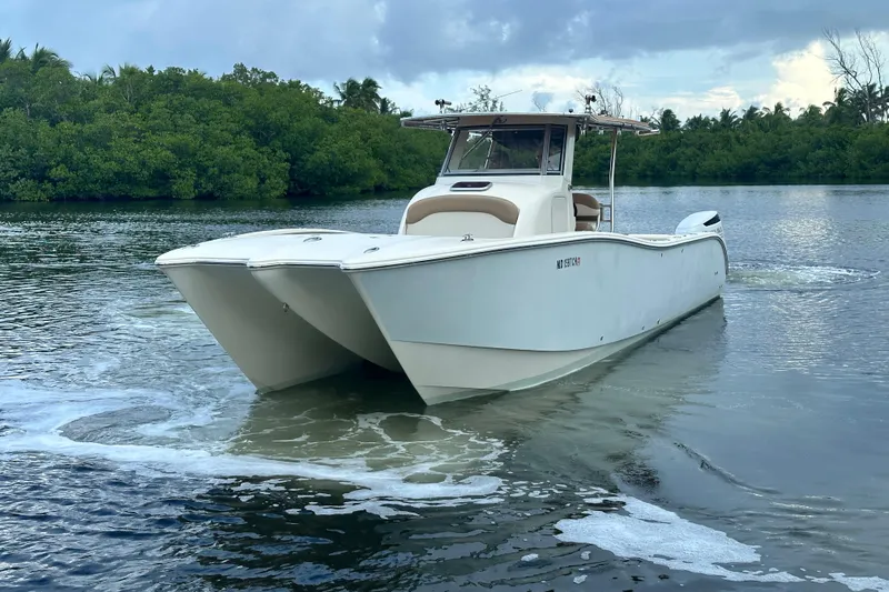  Yacht Photos Pics 2009 Mamba 350 boat on calm water with lush green background.