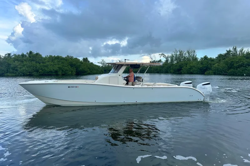  Yacht Photos Pics 2009 Mamba 350 boat cruising on a calm river with lush greenery.