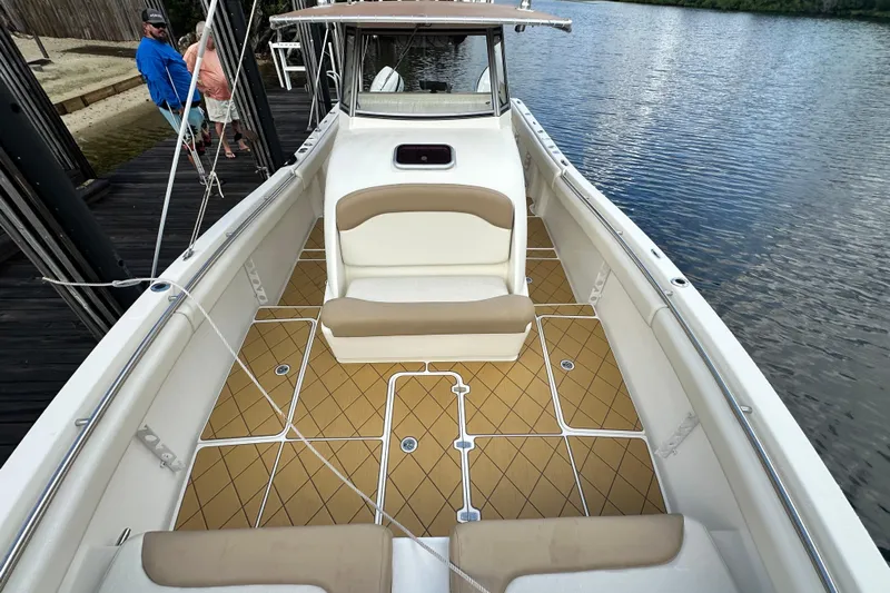  Yacht Photos Pics 2009 Mamba 350 boat with tan seating and deck, docked by a calm river.