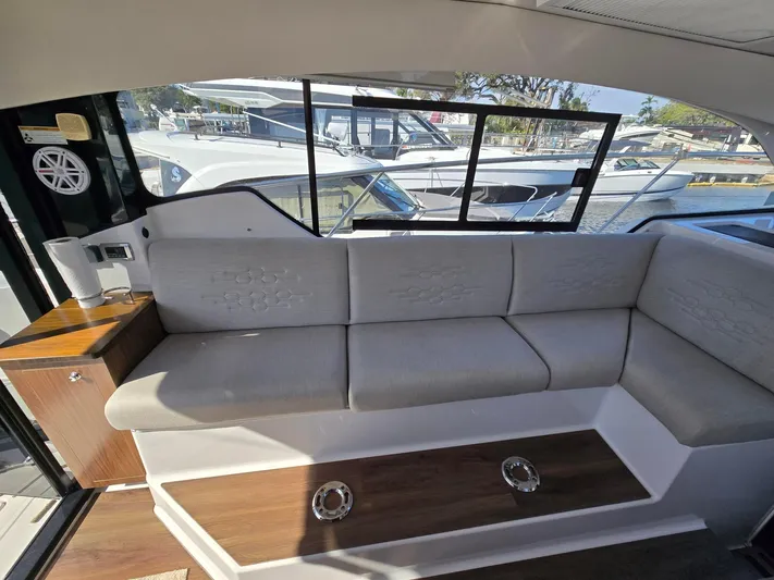 Live It Up Yacht Photos Pics 2020 Four Winns V355FX OB interior with gray seating and window view of marina.