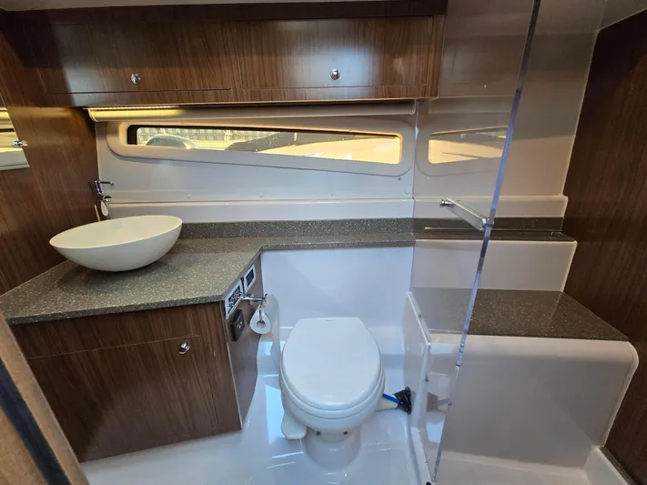 Live It Up Yacht Photos Pics 2020 Four Winns V355FX OB boat bathroom with modern sink, toilet, and wood cabinetry.