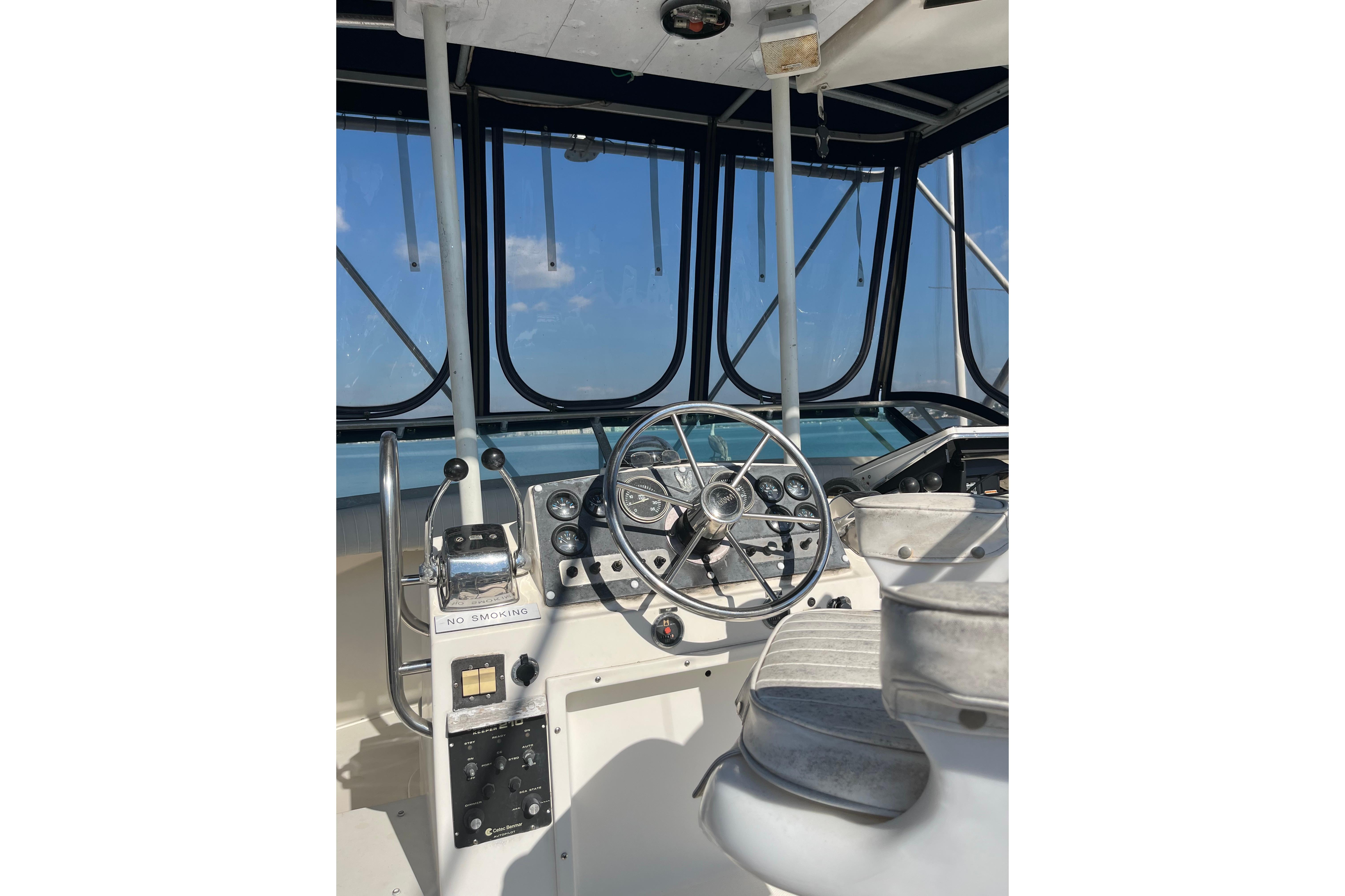 Cockpit of 1981 Bertram 35 Sportfish boat with steering wheel and controls.