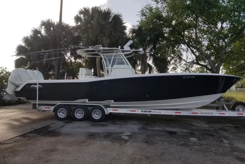  Yacht Photos Pics 2009 Invincible 36 Open Fisherman boat on trailer, parked near trees.