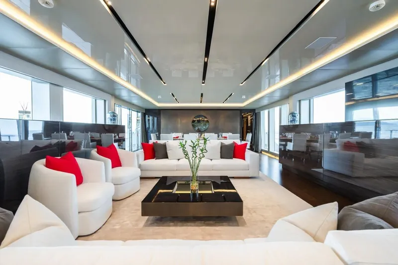 Zig Zag Ocean Yacht Photos Pics Luxurious yacht interior with modern decor, white sofas, red cushions, and elegant lighting, Admiral 45 Meters.