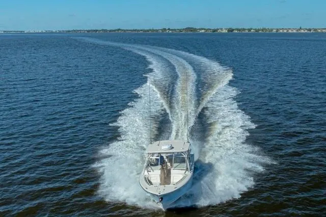  Yacht Photos Pics 2017 Grady-White Freedom 307 boat cruising on open water, leaving a wake.