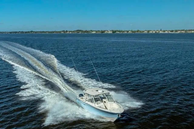  Yacht Photos Pics 2017 Grady-White Freedom 307 boat cruising on open water under clear blue skies.