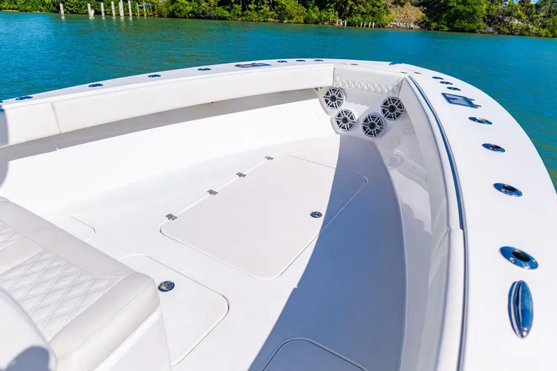  Yacht Photos Pics 2022 Conch 27 boat interior with white seating and speakers, on a sunny day by the water.