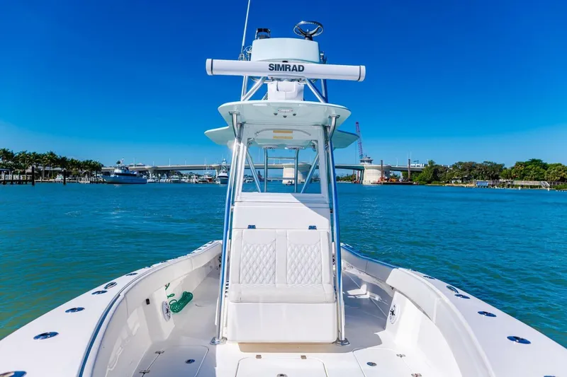  Yacht Photos Pics 2022 Conch 27 boat on clear blue water with a sunny sky backdrop.