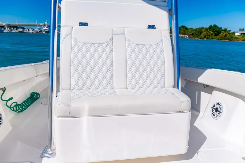  Yacht Photos Pics Luxurious seating on 2022 Conch 27 boat with diamond-stitched upholstery, ocean backdrop.
