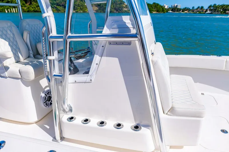  Yacht Photos Pics 2022 Conch 27 boat interior with white seating and chrome details, overlooking blue water.
