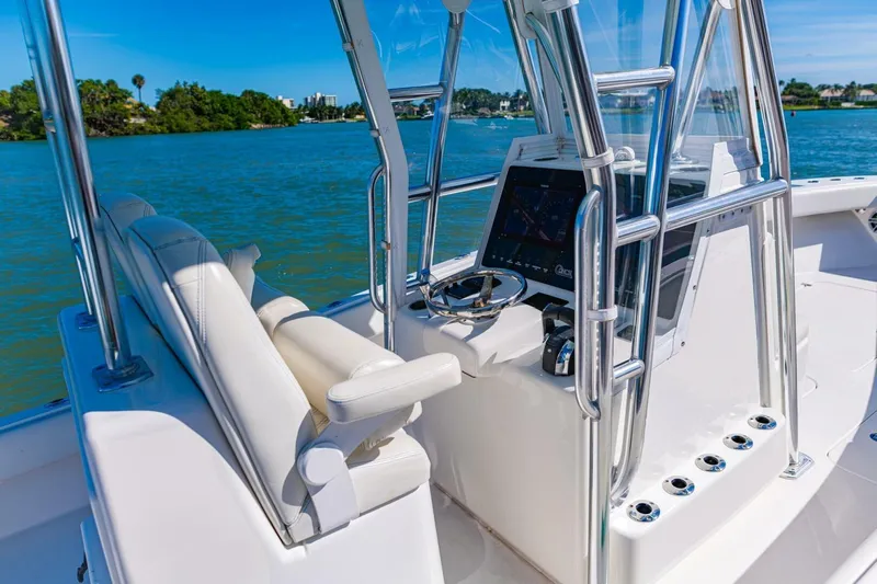  Yacht Photos Pics 2022 Conch 27 boat interior with steering console and seating on a sunny day.