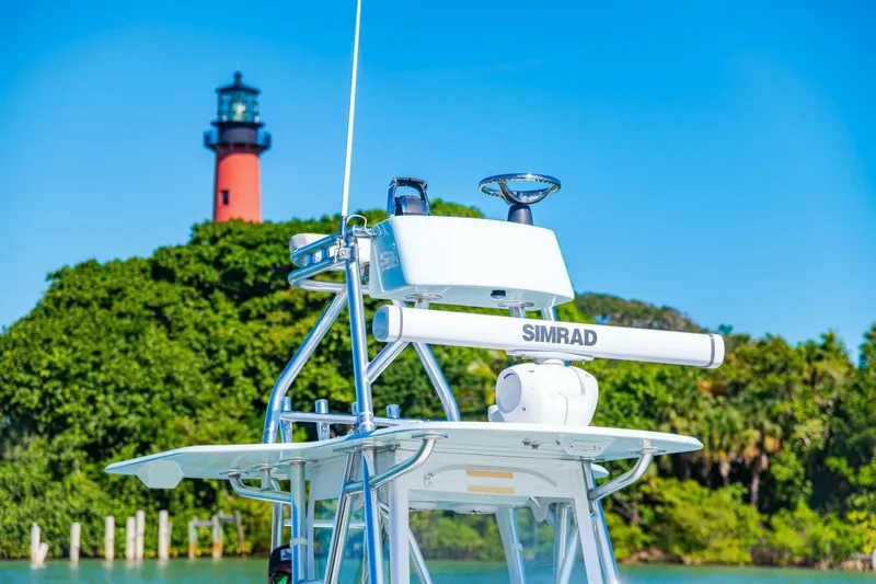  Yacht Photos Pics 2022 Conch 27 boat with Simrad equipment near a lighthouse and lush greenery.