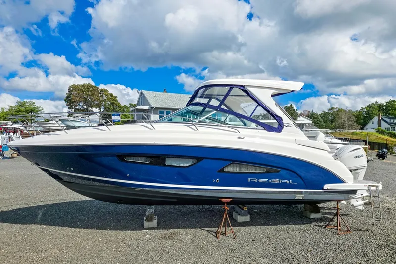  Yacht Photos Pics 2026 Regal 33 XO boat on display, blue and white design, parked outdoors.